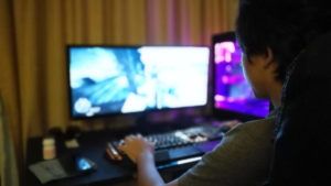 Side View Of Boy Playing Game On Computer At Home