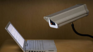 Surveillance camera peering into laptop computer