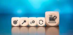 Wooden,Blocks,With,Symbol,Of,System,Maintenance,Concept,On,Blue