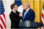 Macron shaking hands with Trump